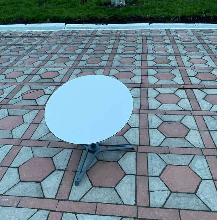 A round Starlink dish on the floor.